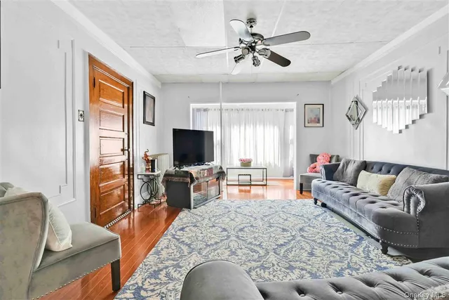 a living room with furniture a flat screen tv and a window