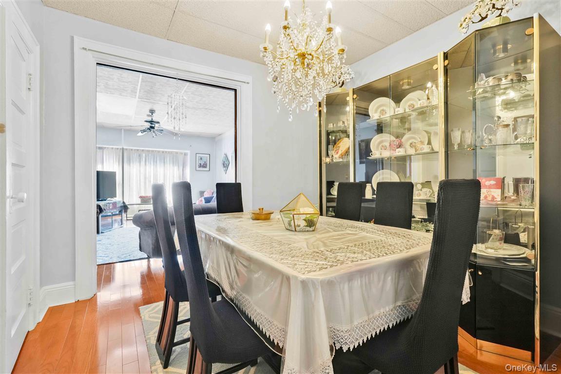 104-21 92nd Avenue Queens, NY 11418 - Photo 9 of 48 a dining room with furniture a chandelier and wooden floor