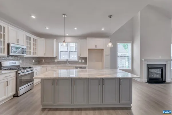 a large kitchen with stainless steel appliances granite countertop a stove a sink and a refrigerator