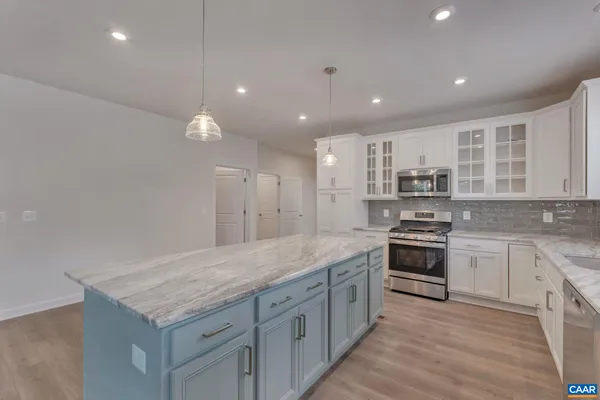 a kitchen with stainless steel appliances granite countertop a sink stove and cabinets