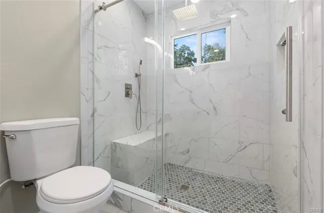 a white toilet sitting next to a bathroom