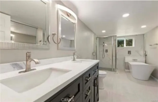 a bathroom with a granite countertop sink a bathtub a mirror and vanity