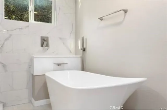 a white bath tub sitting next to a white sink