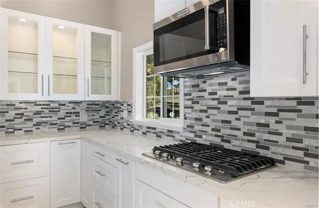 a kitchen with granite countertop a stove a sink and a microwave