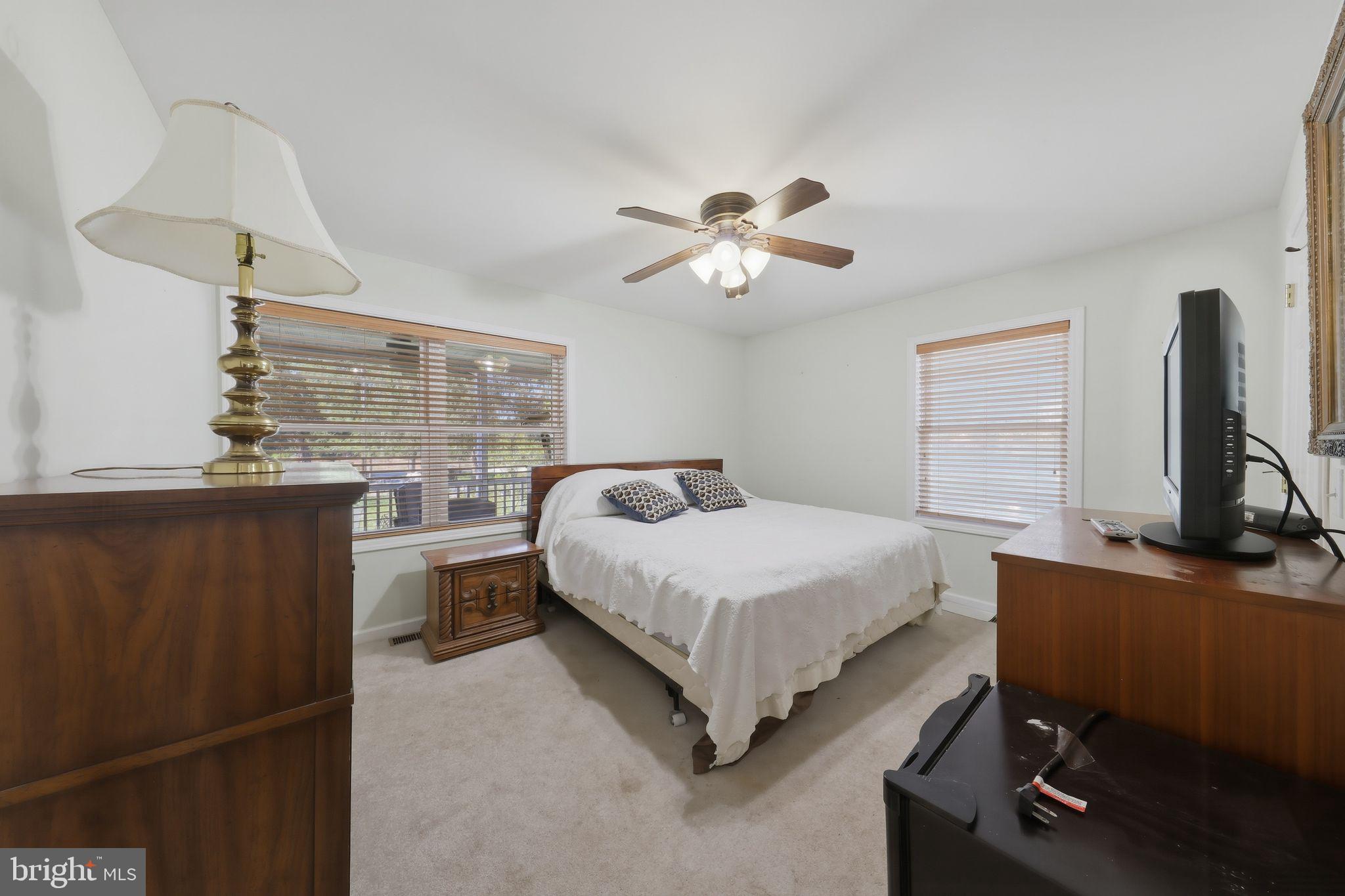 850 Arthursville Road Hartly, DE 19953 - Photo 13 of 40 a spacious bedroom with a bed and a chandelier
