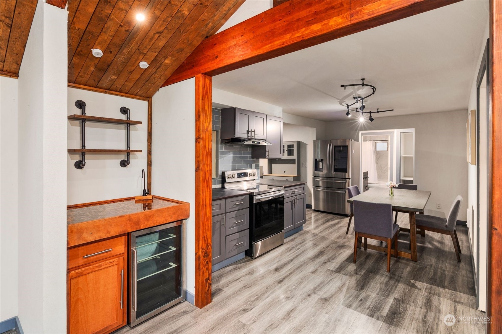 18337 Southeast May Valley Road Issaquah, WA 98027 - Photo 8 of 40 a kitchen with stainless steel appliances granite countertop a stove refrigerator and a dining table with wooden floor