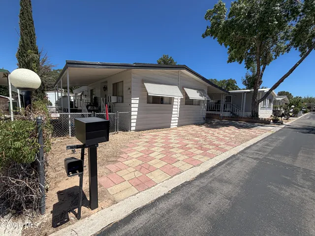 a front view of a house with a yard and potted plants