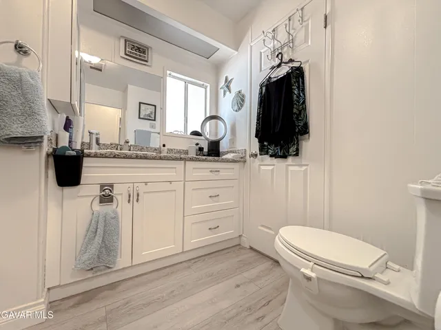 a bathroom with a sink a toilet a mirror and vanity