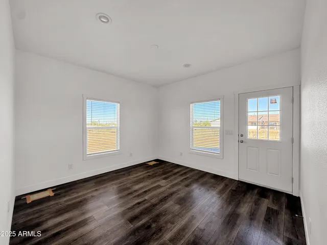 a view of a room that has wooden floor and windows in it