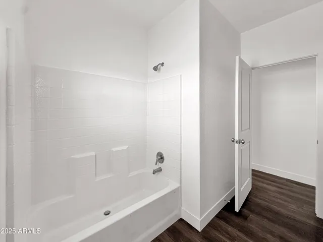 a utility room with a sink a vanity and wooden floor