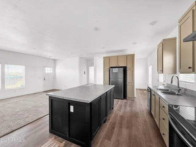 a kitchen with stainless steel appliances granite countertop a sink stove and refrigerator