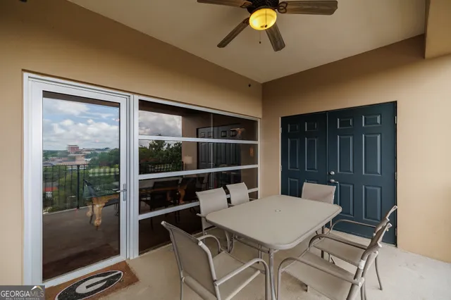 a view of a balcony with floor to ceiling windows and wooden fence