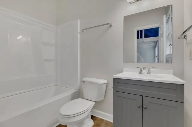 a bathroom with a granite countertop toilet a sink and a bathtub