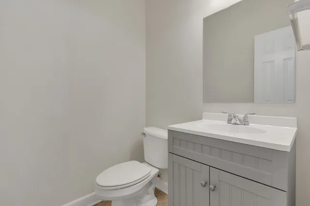 a bathroom with a toilet a sink and mirror