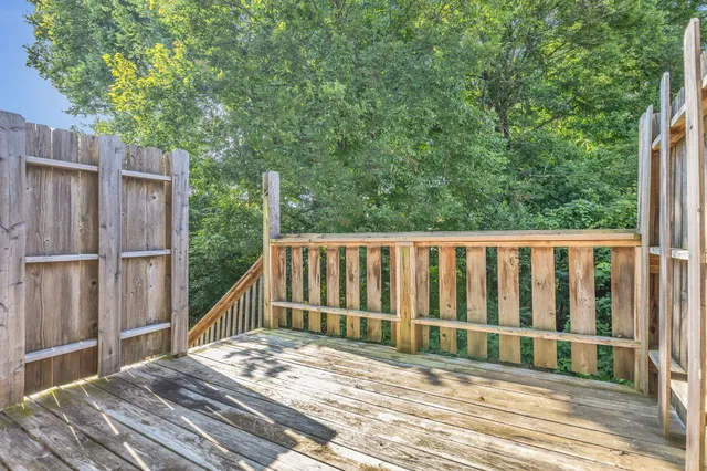 a view of balcony with wooden floor and fence