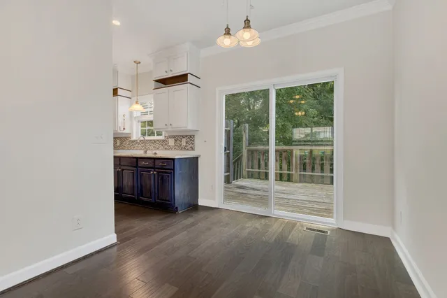 an empty room with wooden floor and a window