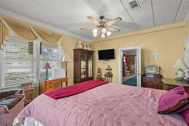 a bed room with a bed mirror and a flat tv screen