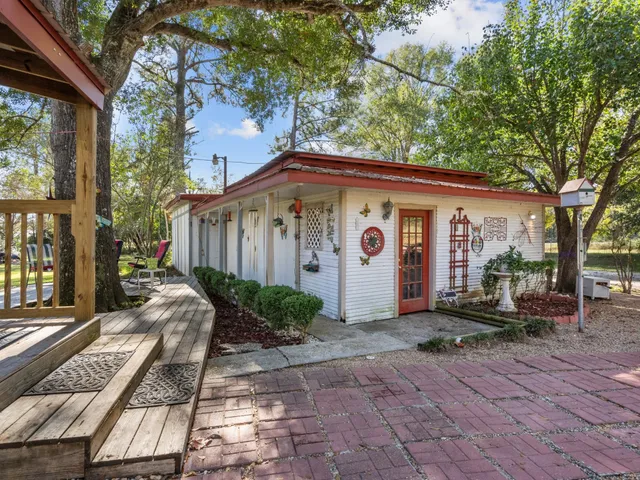 a view of house with patio outdoor seating and trees