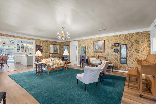 a living room with patio furniture and a chandelier
