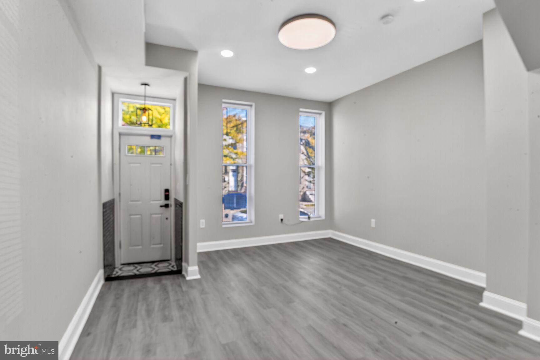 1108 South Carey Street Baltimore, MD 21223 - Photo 3 of 24 an empty room with window and wooden floor