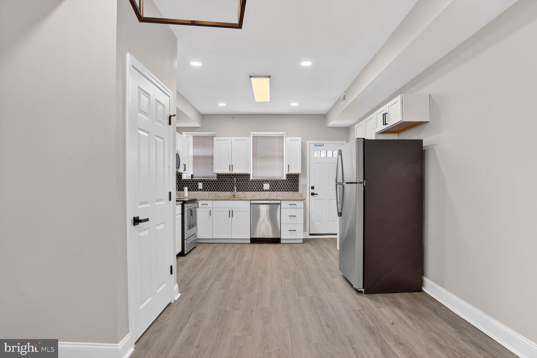 1108 South Carey Street Baltimore, MD 21223 - Photo 7 of 24 a kitchen with a refrigerator a sink and cabinets