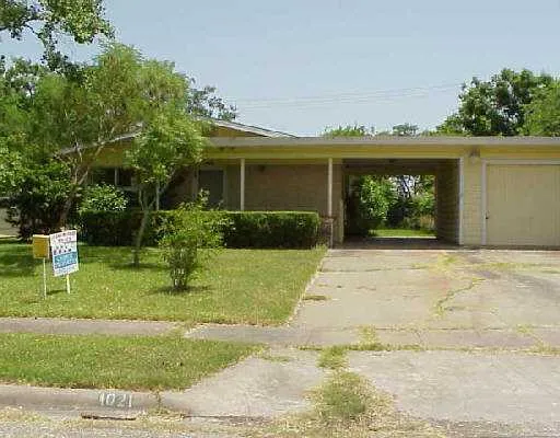 a front view of a house with a yard and potted plants