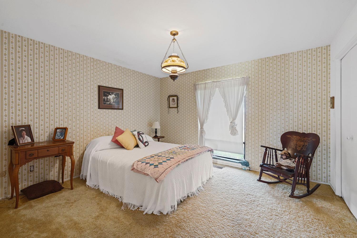 3270 Jackson Valley Road Ione, CA 95640 - Photo 17 of 34 a bedroom with a bed and a chandelier