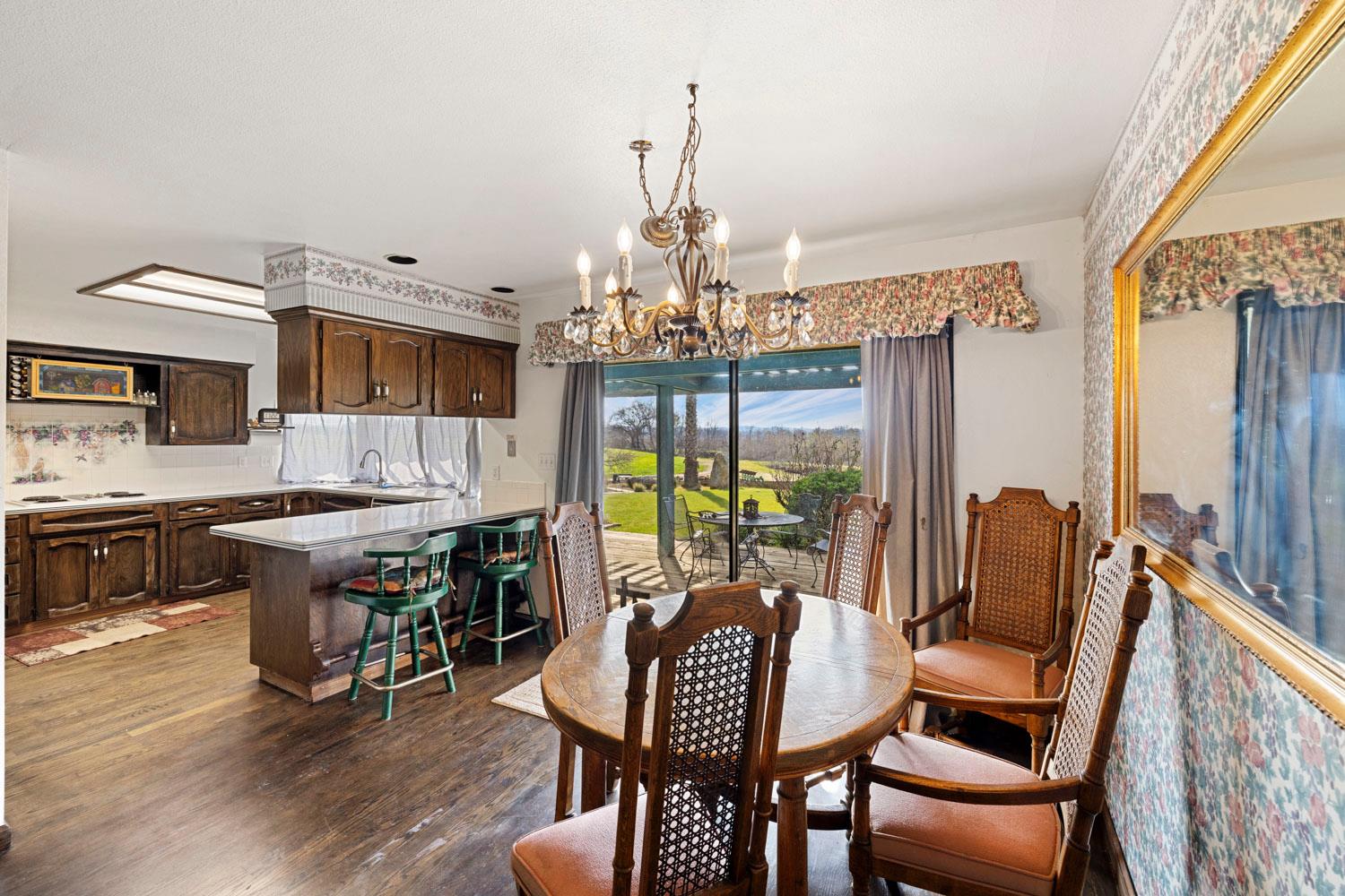 3270 Jackson Valley Road Ione, CA 95640 - Photo 10 of 34 a dining room with furniture a chandelier and wooden floor