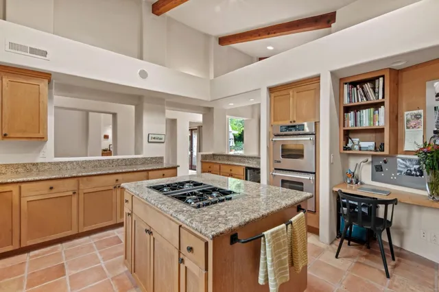 a kitchen with a stove a sink dishwasher and white cabinets with wooden floor