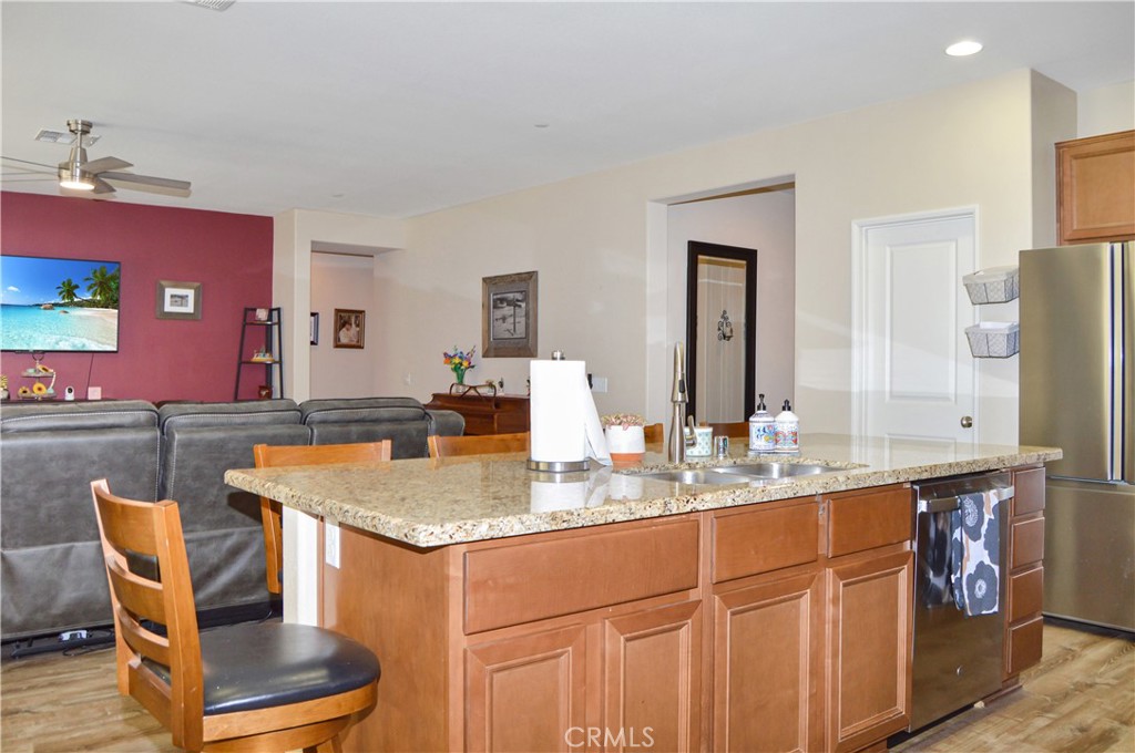 166 Fox Lane Calimesa, CA 92320 - Photo 20 of 76 This Kitchen is a Great Place to Gather with Granite-topped Counters, Island Seating, Stainless Steel Appliances, a Coffee Bar, and a Walk-in Pantry - All Open to the Living Area, Dining Room, and Back Patio (TV screen simulated)