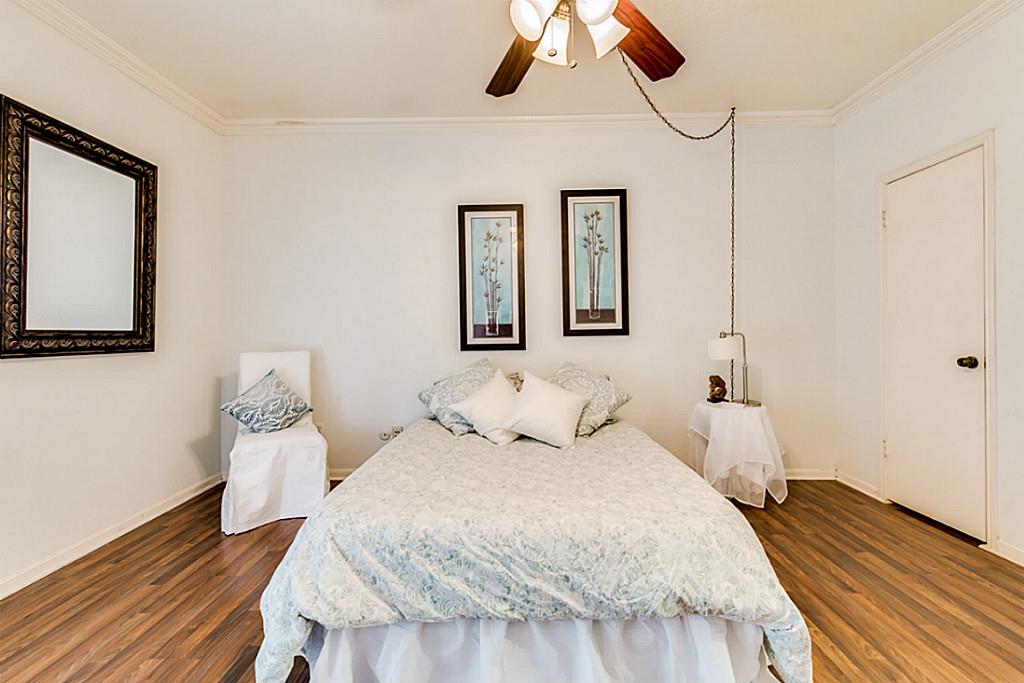 2100 Tanglewilde Street, Unit 296 Houston, TX 77063 - Photo 18 of 31 a bedroom with a bed and wooden floor