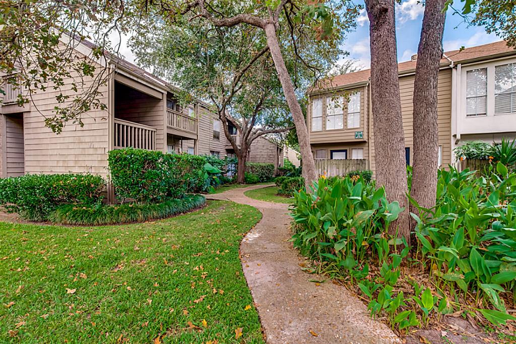 2100 Tanglewilde Street, Unit 296 Houston, TX 77063 - Photo 26 of 31 a front view of a house with a yard and trees