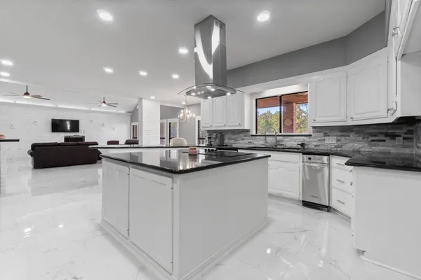 a kitchen with stainless steel appliances granite countertop a sink a stove and cabinets