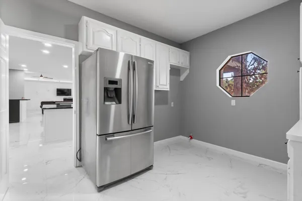 a kitchen with stainless steel appliances granite countertop a refrigerator and a sink