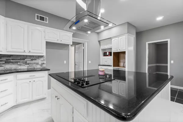 a kitchen with stainless steel appliances granite countertop a sink stove and cabinets