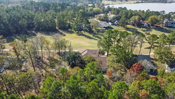 an aerial view of residential house with outdoor space and trees all around