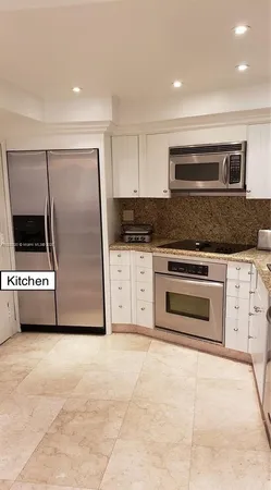 a kitchen with stainless steel appliances kitchen island granite countertop a stove a refrigerator and a sink