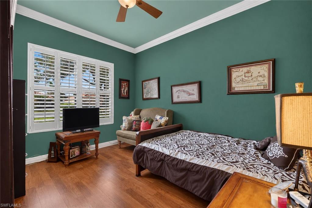9970 Rookery Circle Estero, FL 33928 - Photo 21 of 50 Hardwood flooring, crown molding, ceiling fan, and white plantation shutters