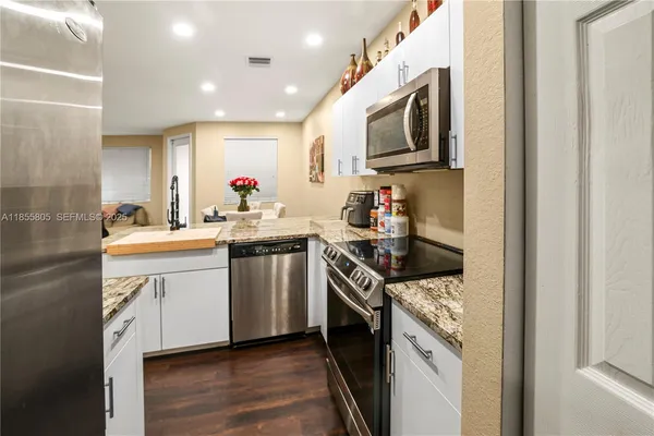 a kitchen with stainless steel appliances granite countertop a sink and a stove