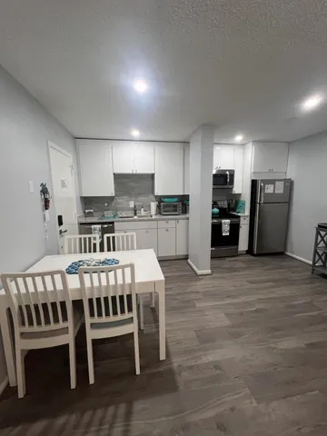 a large kitchen with a table and chairs