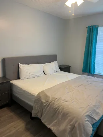 a large bed sitting in a bedroom next to a window