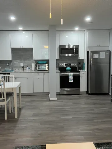 a kitchen with stainless steel appliances granite countertop a stove a refrigerator and a stove top oven