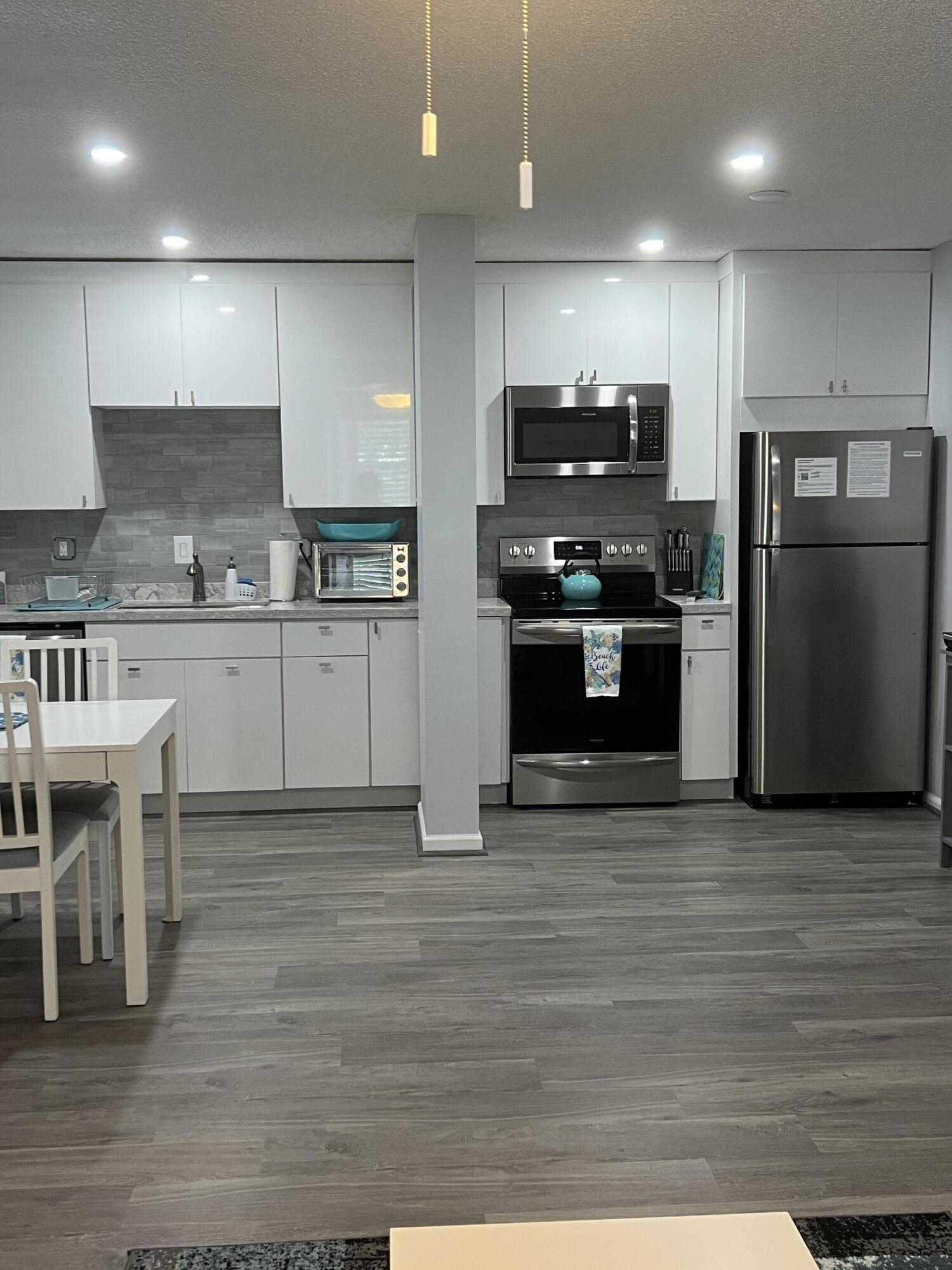 2271 Northeast 68th Street, Unit 2022 Fort Lauderdale, FL 33308 - Photo 2 of 22 a kitchen with stainless steel appliances granite countertop a stove a refrigerator and a stove top oven