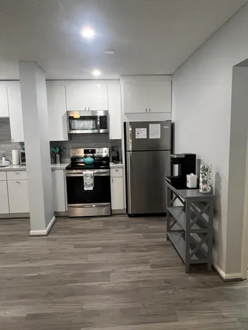 a kitchen with a refrigerator and a stove top oven