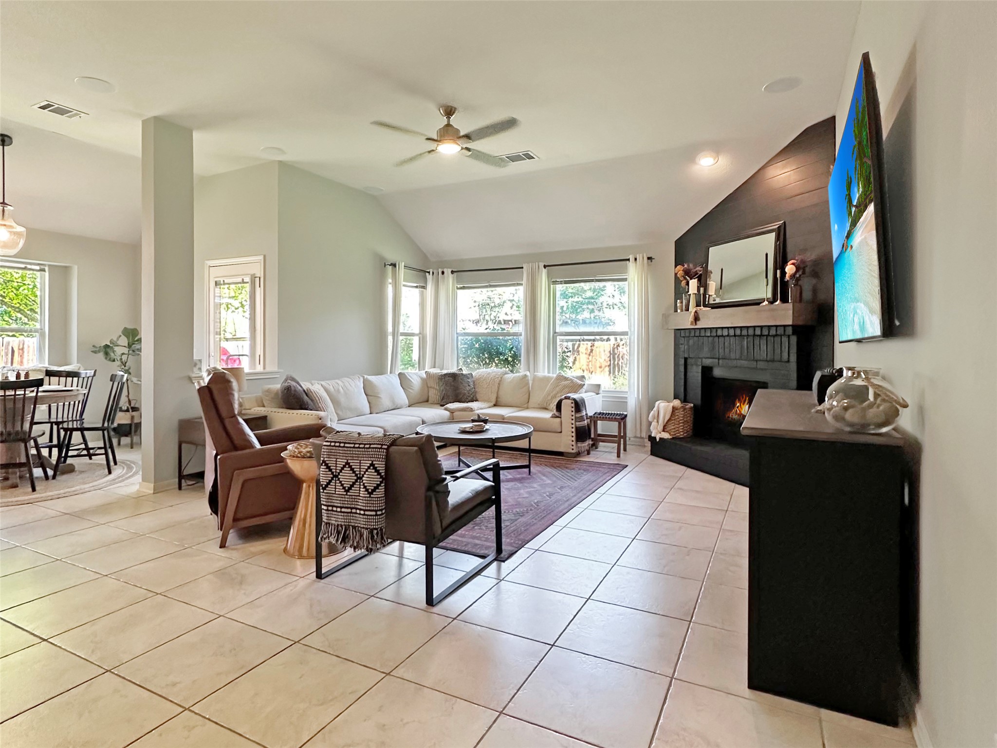 20213 Kearney Hill Road Pflugerville, TX 78660 - Photo 7 of 27 A corner fireplace and vaulted ceilings define this inviting, naturally illuminated living space.