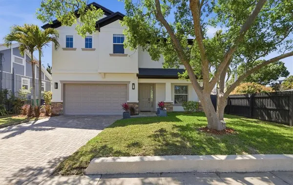 a view of a house with backyard and a tree