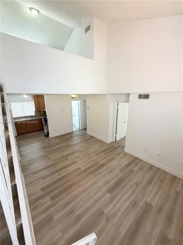 a view of a room with wooden floor