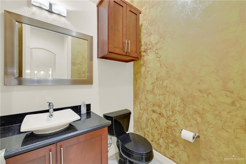 3601 North Toledo Street Pharr, TX 78577 - Photo 15 of 21 a bathroom with a granite countertop toilet sink and mirror