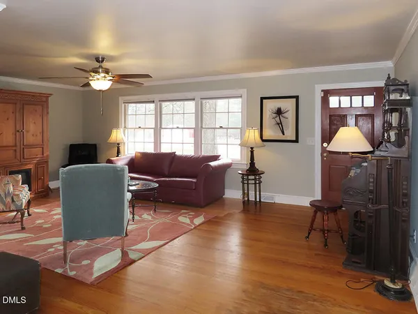 a living room with furniture a chandelier and a window
