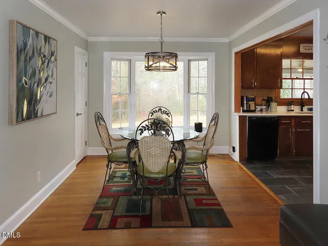 a dining room with furniture a chandelier and wooden floor